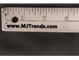 Closeup shot of ruler on top of black imitation leather material. thumbnail image.