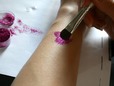Using body adhesive to apply glitter tattoo. thumbnail image.