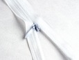 Close-up of zipper pull on white nylon invisible zipper. thumbnail image.