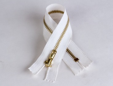 White zipper with brass gold colored teeth.